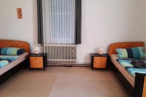 Una sala de estar con dos camas y una ventana. en Ferienwohnung am Wildgehege bei Walsrode, en Walsrode