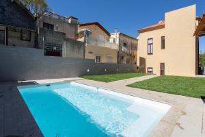 a swimming pool in a yard next to a building at Host Wise - Sunny Bright Duplexes & Pool in Vila Nova de Gaia