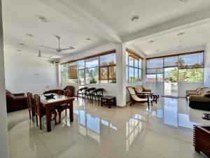 a large living room with a table and chairs at Bliss Apartment Hikkaduwa in Hikkaduwa