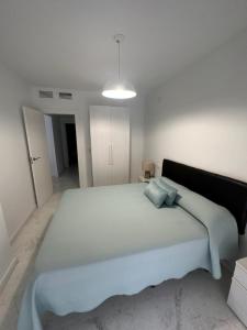 Un dormitorio con una cama grande en una habitación blanca. en Fesemar, en San Juan de los Terreros