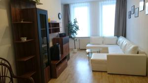 a living room with a white couch and a tv at Ferienwohnung am Markt in Quedlinburg