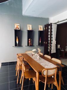 ein Esszimmer mit einem Holztisch und Stühlen in der Unterkunft Omah lempong in Kejayan