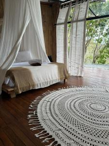 una camera con un letto e un tappeto su un pavimento in legno di SPICE TRADER a Nusa Penida