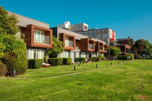 a row of buildings with a green lawn in front at Palmalife Bodrum Resort & Spa in Yalıkavak