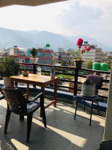 a table and chairs on a balcony with a view at Lucky Pokhara Apartment in Pokhara