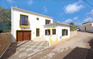 a white house with a gate and a driveway at Casa Bellarosa in Raposeira