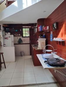 a kitchen with red brick walls and a counter top at Casa em São Pedro da Aldeia in São Pedro da Aldeia