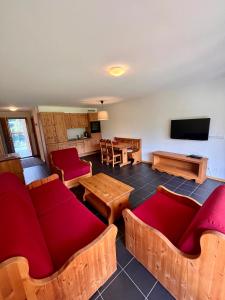 瓦尔·蒂利兹Aparthotel Mountain River Resort的客厅配有红色的沙发和桌子