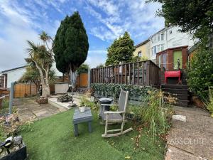 un jardín con una mesa y una silla en un patio en Charming bungalow, en Paignton