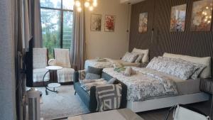 a bedroom with two beds and a couch and a window at Green Therapy Cottage in Ranau