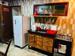 a kitchen with a white refrigerator and a sink at Duplex Villas Areias do Patacho - Praia do Patacho - Porto Pedras in Pôrto de Pedras