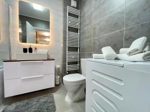 a bathroom with a toilet and a sink and a mirror at Apartment No 506 Lebada Lake in Pantelimon +26 photos