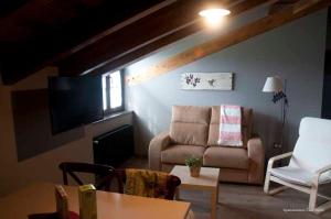sala de estar con sofá y mesa en Casa Pacho Apartamentos Rurales, en Luarca