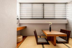 a dining room with a table and chairs and a window at suye hotel in Taichung