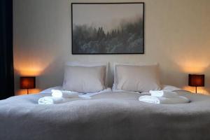 ein weißes Bett mit zwei Kissen und einem Bild an der Wand in der Unterkunft Kaksio lähellä keskustaa in Iisalmi