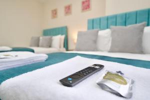 a remote control sitting on top of a bed at Cosy 1Bed Flat with Garden, Parking & Free Netflix in Coventry