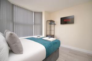 a bedroom with a bed and a tv on the wall at Cosy 1Bed Flat with Garden, Parking & Free Netflix in Coventry