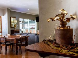 a living room with a table and a dining room at Fairway Lodge in Pongola
