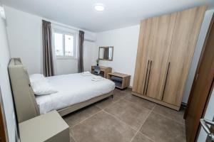 a bedroom with a bed and a wooden cabinet at The Urban Oasis Chic 2-Bedroom Penthouse in St Paul's Bay