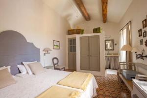 a bedroom with a large white bed and a chair at Les Beaumettes, villa provençale à deux pas de Gordes in Beaumettes +22 photos
