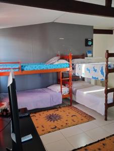 a room with two bunk beds and a desk at Casa em São Pedro da Aldeia in São Pedro da Aldeia +56 photos