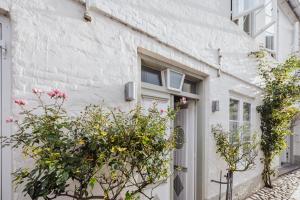 a white building with flowers in front of a door at Stadthaus Flensburg in Flensburg