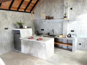 a white kitchen with a sink and a counter at Malilo Dream in Galle
