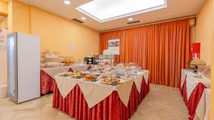 a long table with plates of food on it at Hotel Nobel in Rimini