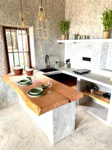 a kitchen with a wooden table with plates and glasses at Malilo Dream in Boossa