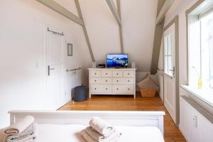 a bedroom with a bed and a tv on a dresser at Stadthaus Flensburg in Flensburg