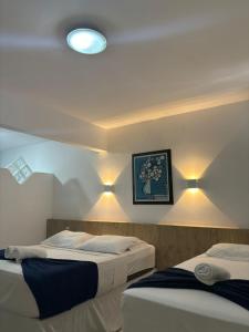 two beds in a room with lights on the wall at Praia Hotel Enseada in Maceió +37 photos