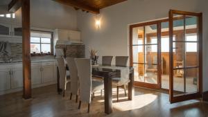 a dining room with a table and white chairs at Kuća za odmor Belle Amie in Krapina