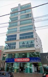a tall building with a sign in front of it at Ap novo e climatizado no centro com ótima localização na avenida principal in Piratuba