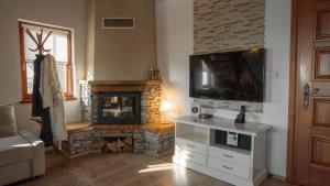 a living room with a fireplace and a flat screen tv at Kuća za odmor Belle Amie in Krapina