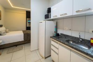 a kitchen with a refrigerator and a bed in a room at Lindo e Confortável Espaço - MEL509 in Maringá
