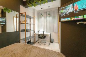 a room with a bed and a desk and a tv at Lindo e Confortável Espaço - MEL509 in Maringá