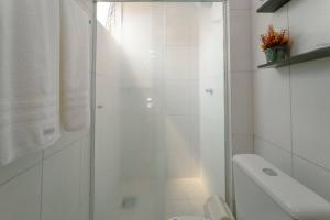 a white bathroom with a shower and a toilet at Lindo e Confortável Espaço - MEL509 in Maringá