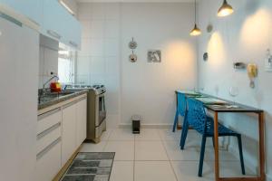 a kitchen with a table and blue chairs in it at Lindo e Confortável Espaço - MEL509 in Maringá +16 photos