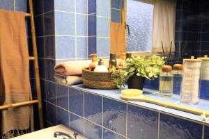 a blue tiled bathroom with a sink and a mirror at Villa Kolck in Xanten