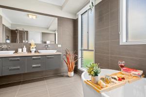 a bathroom with a tub and a sink and a mirror at Luxury Hunter Valley Acreage - Heated SwimSpa - Mountain Views - Pool Table - Fire Pitt in Millfield
