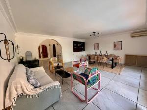 a living room with a couch and chairs and a table at Villa Perpignan avec piscine - Route des plages in Perpignan