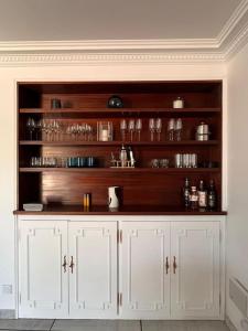 a kitchen with white cabinets and wooden shelves at Villa Perpignan avec piscine - Route des plages in Perpignan