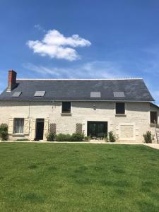 una gran casa blanca con paneles solares. en La Huberdière, en Fondettes
