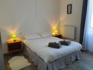 a bedroom with two beds and two lamps on tables at Hôtel de la promenade in Bains-les-Bains