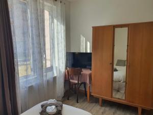 a bedroom with a bed and a dresser with a mirror at Hôtel de la promenade in Bains-les-Bains