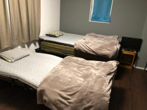 a room with three beds in a room at 智翔はうす 駐車場無料 民泊で女性家主滞在型 予約後はメール確認願います in Kumamoto