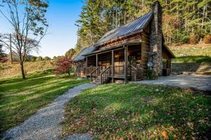 a log cabin in the woods with a path leading to it at Goldilocks in Canton
