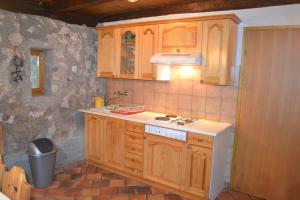 a kitchen with wooden cabinets and a stove top oven at House Pod Lipo in Trenta