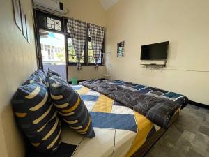 a room with four beds and a flat screen tv at Dehome Pakuwon Mall 2 Syariah in Surabaya