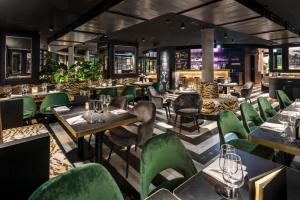 ein Restaurant mit grünen Stühlen und Tischen in der Unterkunft Central Plaza in Zürich